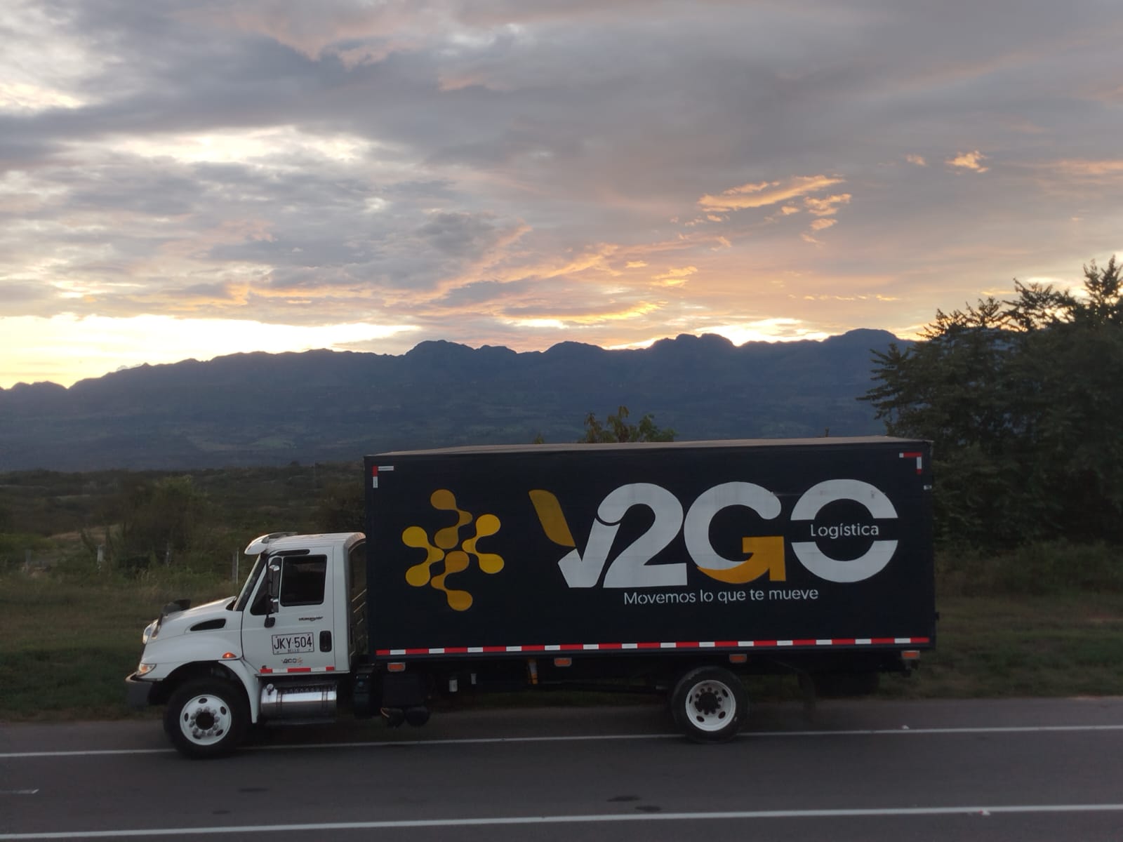 Camión V2GO en ruta al atardecer por una carretera colombiana